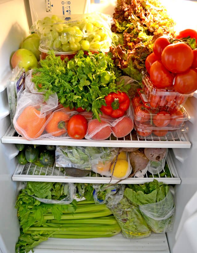 Fruits and vegetables fill a refrigerator