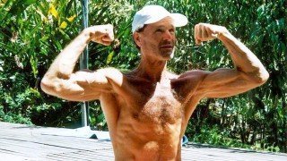 Dr. Doug Graham flexes his biceps outside