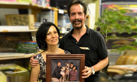 Tim and Leslie Arnold pose with a photograph after the June 2013 potluck at Arnold's Way