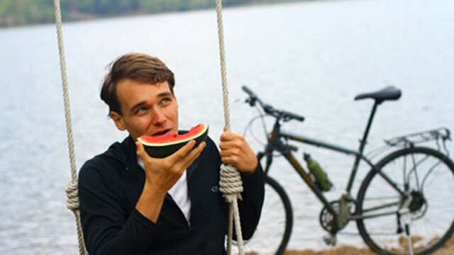 Andrew Perlots eats a watermelon slice and looks into the distance