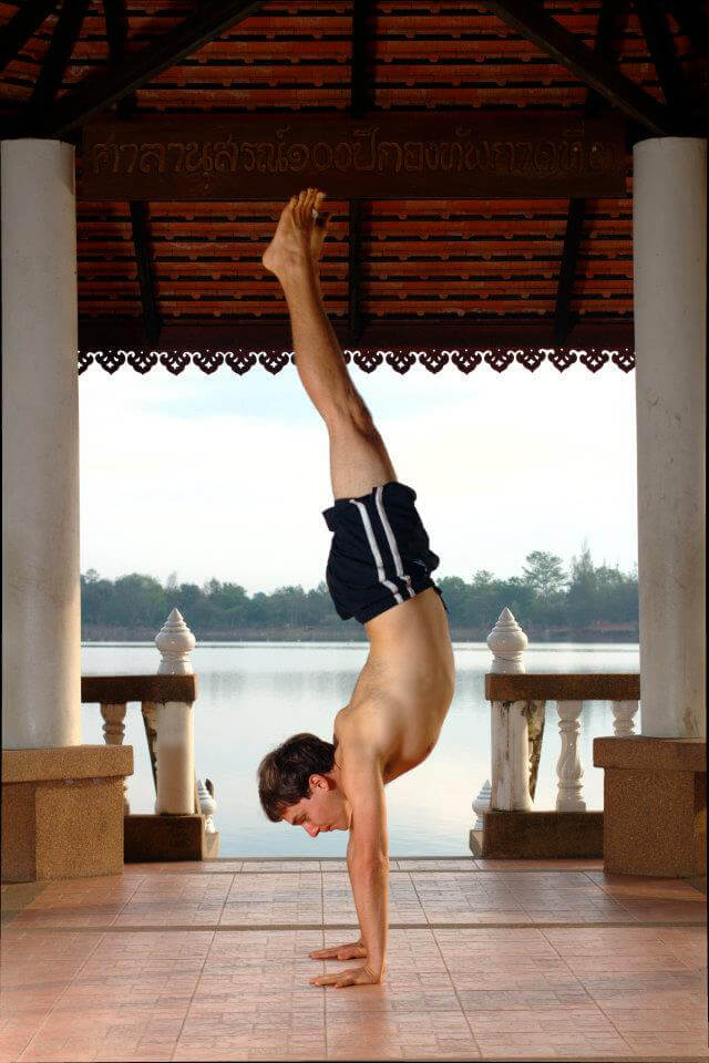 Andrew Perlot performs a handstand by a body of water
