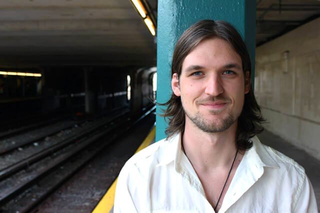Josh Fossgreen poses at a train station