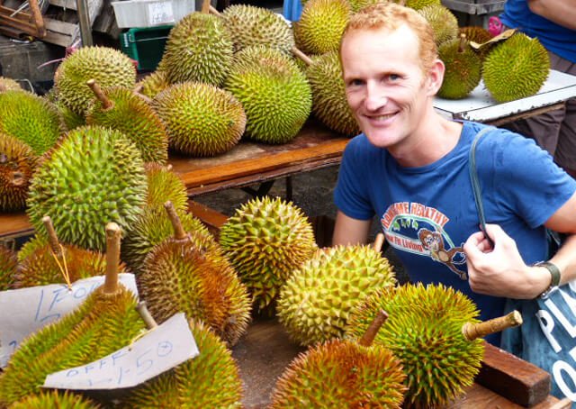 Paul Tarbath smiles in a durian market