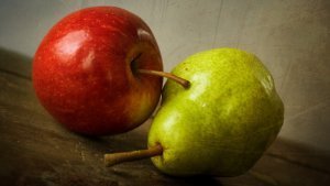 An apple and pear against rustic background