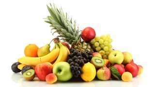 Apples, bananas, grapes and other fruits against a white background
