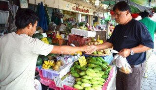 A man purchases fruits at Muang Mai Market in Chiang Mai, Thailand