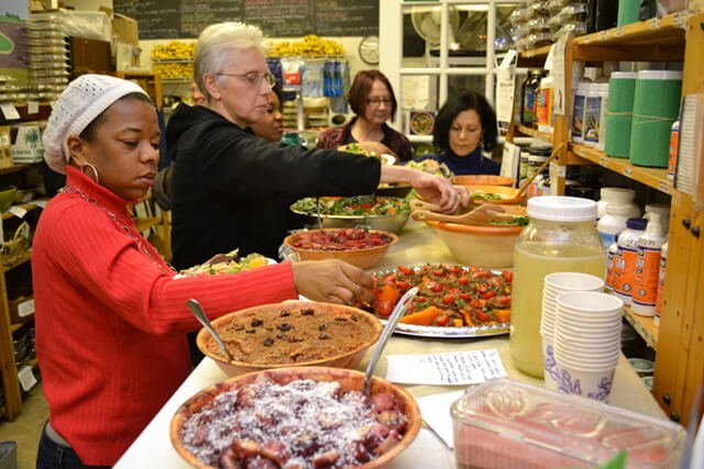 Women fill their plates at the February 2013 potluck at Arnold's Way