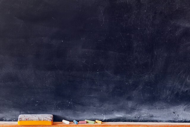 Blank blackboard with colored chalks