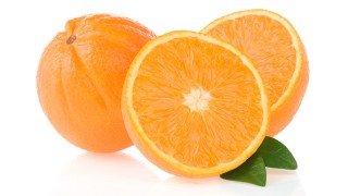 Whole and halved oranges against white background