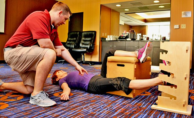 Joan Adams performs Progressive Supine Groin while Mike Kenny oversees