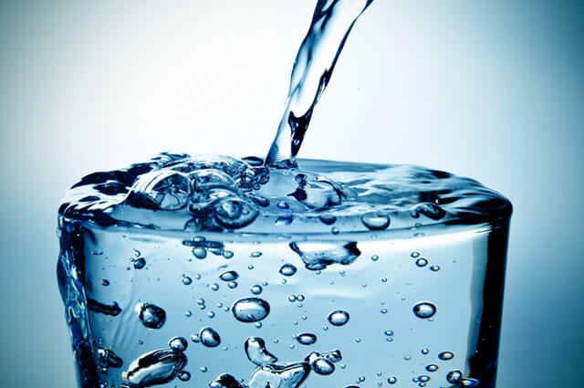 Water pours into an overflowing glass