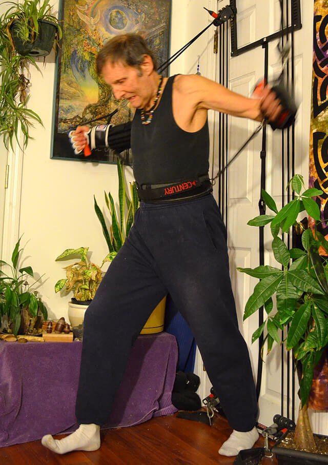 Arnold Kauffman exercises using resistance bands secured against a door