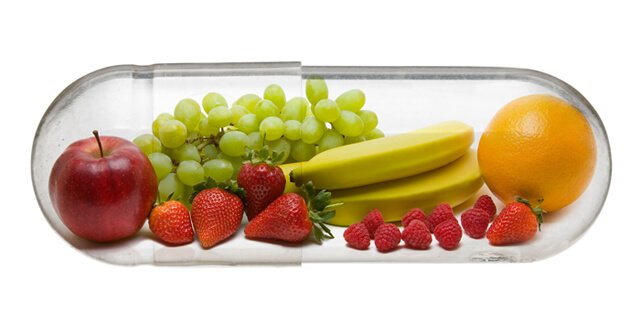 Fruits in a vitamin capsule against a white background