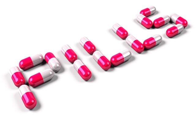 Pink-and-white pills spell out the word "pills"