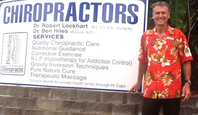 Robert Lockhart standing beside his chiropractic office sign