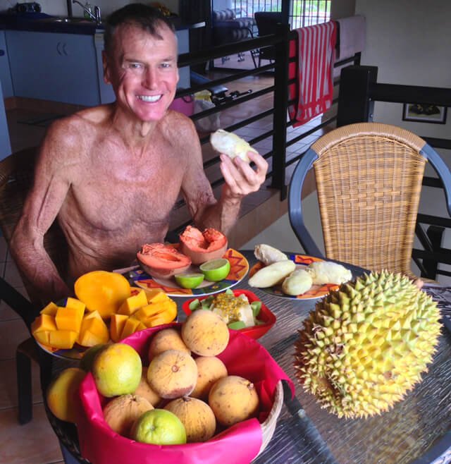 Robert Lockhart eats fruit on a dining room table