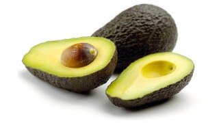 A whole and halved avocado against a white background