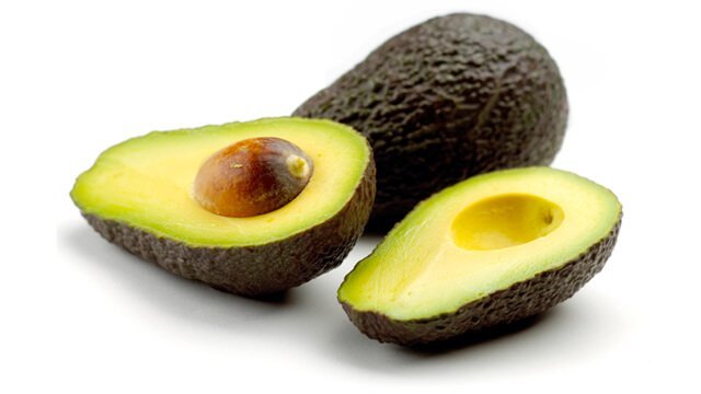 A whole and halved avocado against a white background