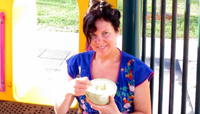 Joy King is photographed eating a melon at a playground