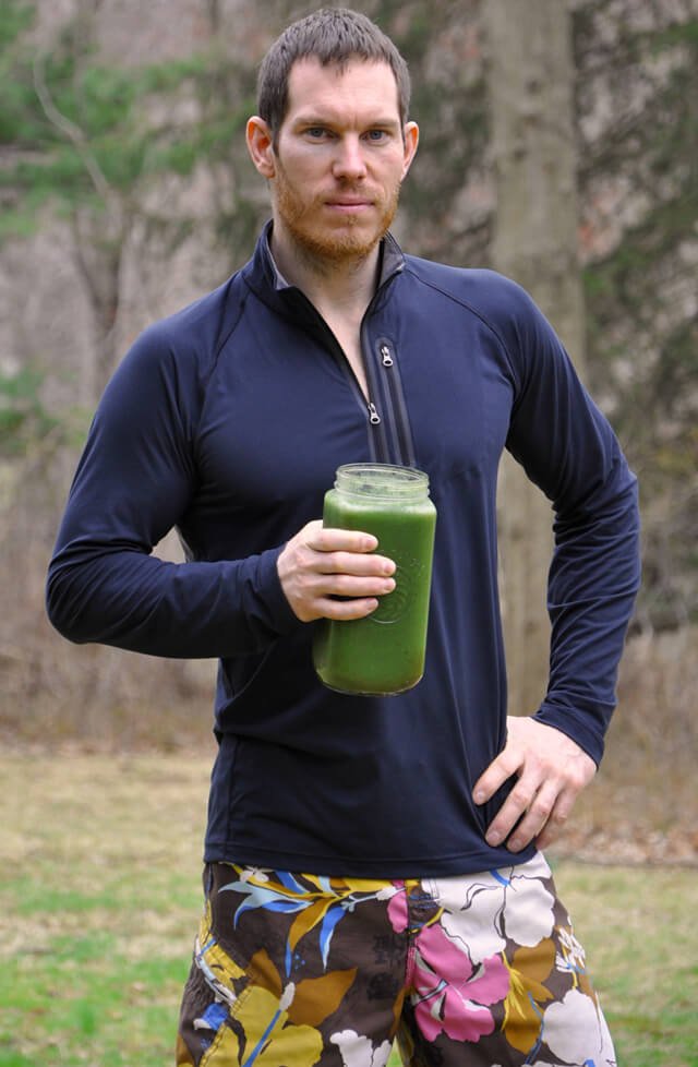 Korey Constable poses while holding a large green smoothie