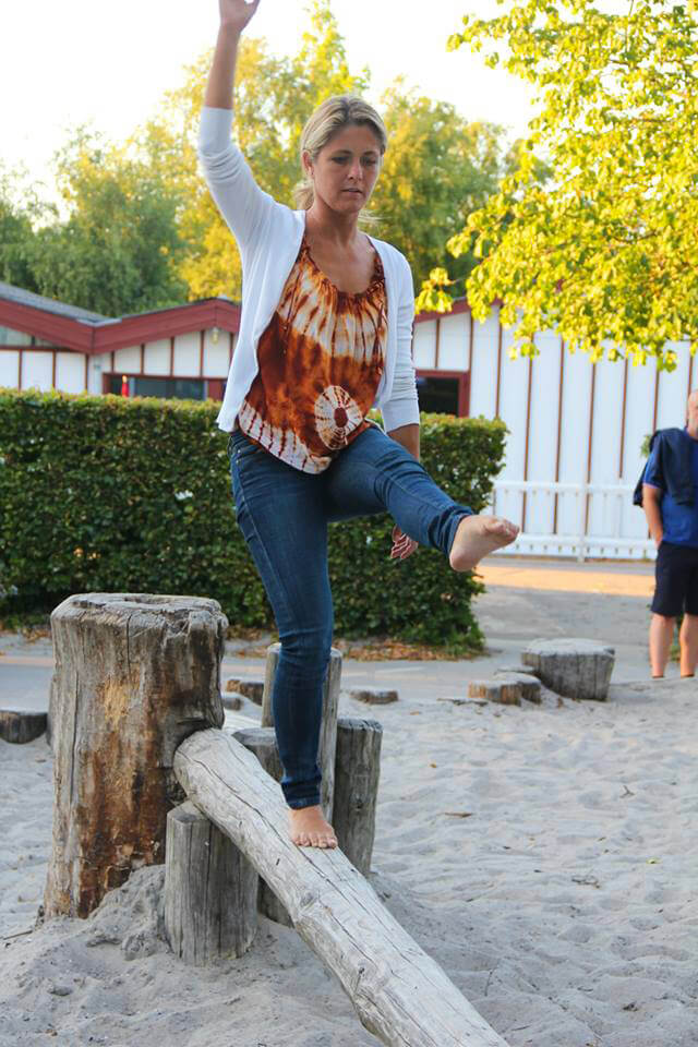 Louise Koch balances on a wooden beam in a park