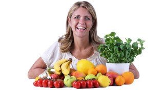 Louse Koch smiles behind a mound of fruit