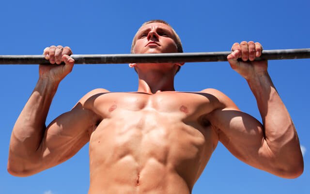 Man completing a pull-up outside