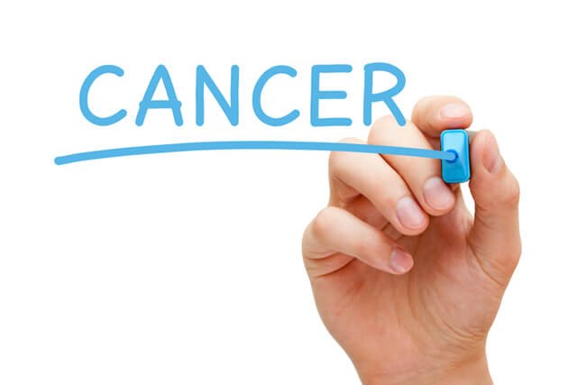 Woman writes the word "cancer" in blue marker