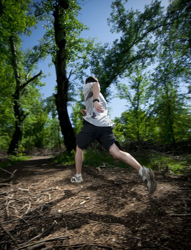 A man runs along a path in woods