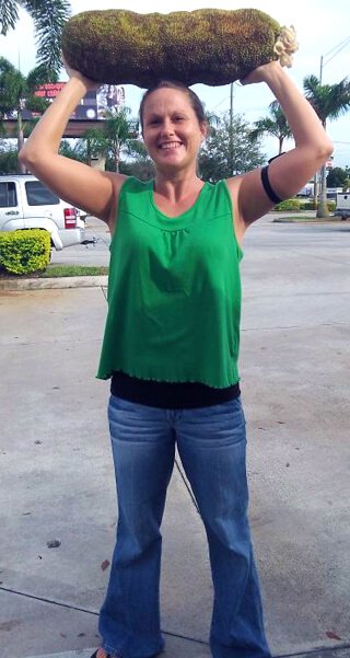 Tasha Lee lifts a large jackfruit over her head