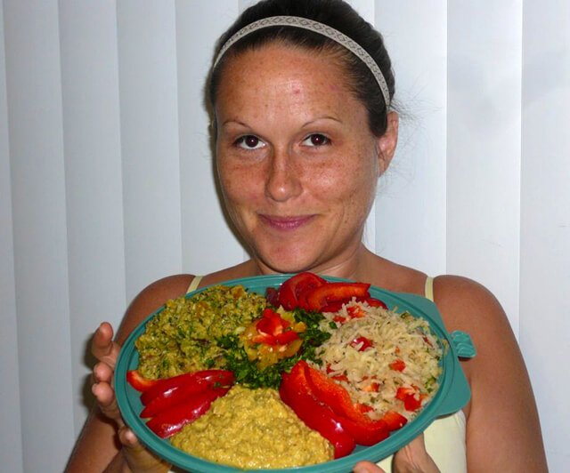 Tasha Lee smiles while holding a platter of raw food