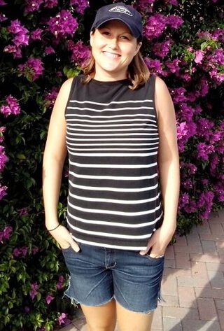 Tasha Lee poses in front of flowering bushes