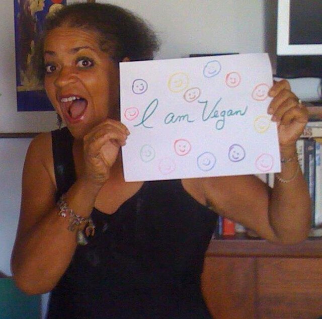 Toni Allen holds a hand-drawn sign saying, "I am Vegan."