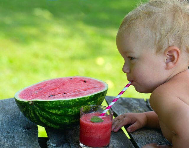 A tot drinks a watermelon smoothie