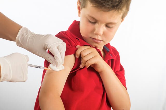 A boy receives a shot