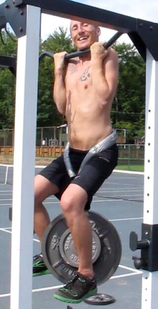 Rob "Freedomfighter" Rehnmark practices chin-ups with additional weight