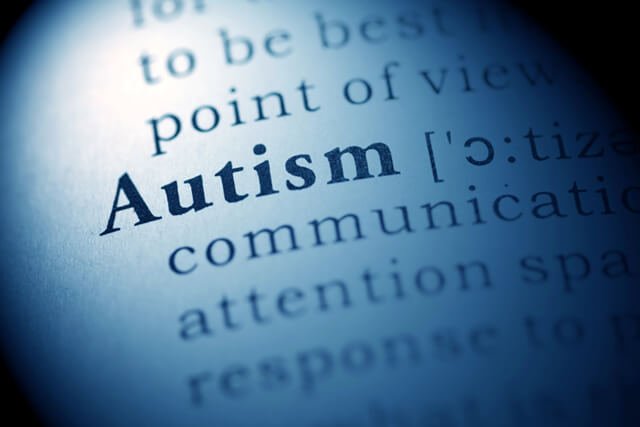 The word "autism" spotlighted in a dictionary