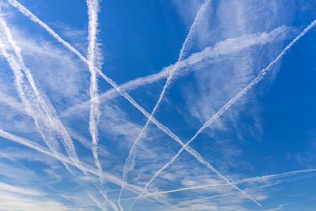 Chemtrails criss-crossing a blue sky