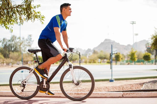 Man rides a bicycle along a path outside