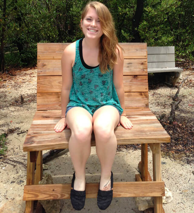 Stephanie Kent sits in a large wooden chair