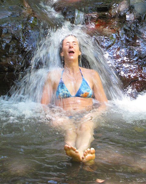 Ellen Livingston getting splashed under a waterfall