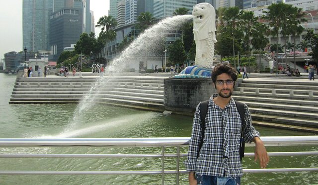 Moein Nejad photographed by a body of water in a city