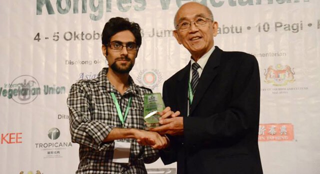 Moein Nejad shakes hands while posing at Vegfest in Malaysia in 2013