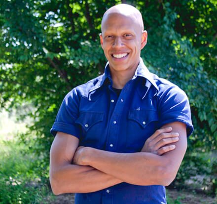 Cyrus Khambatta smiling with arms folded outside
