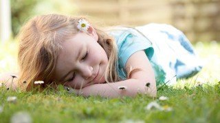 A young girl sleeps on grass
