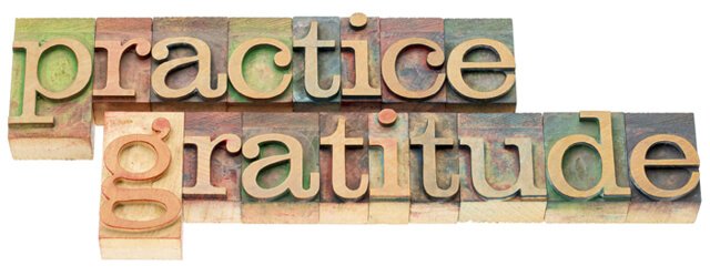 The words "practice gratitude" in wood type