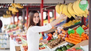 Young woman buying bananas at a market
