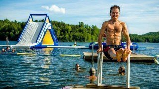 Dr. Samuel Mielcarski flexes by a lake at The Woodstock Fruit Festival