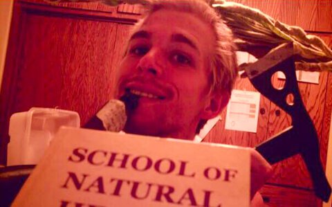 Jason Kvestad holds a School of Natural Health book