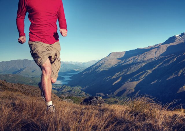 Man runs with mountains in the distance